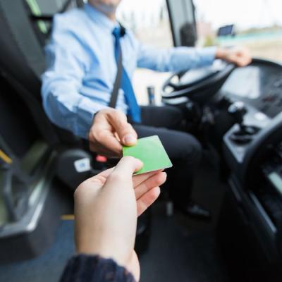 Hand på buss som ger ett busskort till busschaffören