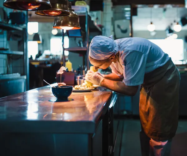 Kock i restaurangkök som förbereder maten