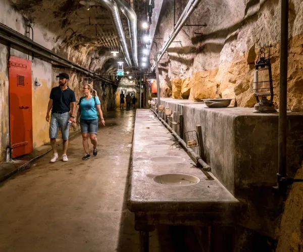 Två som promenerar i en korridor unde marken i en gamal militäranläggning